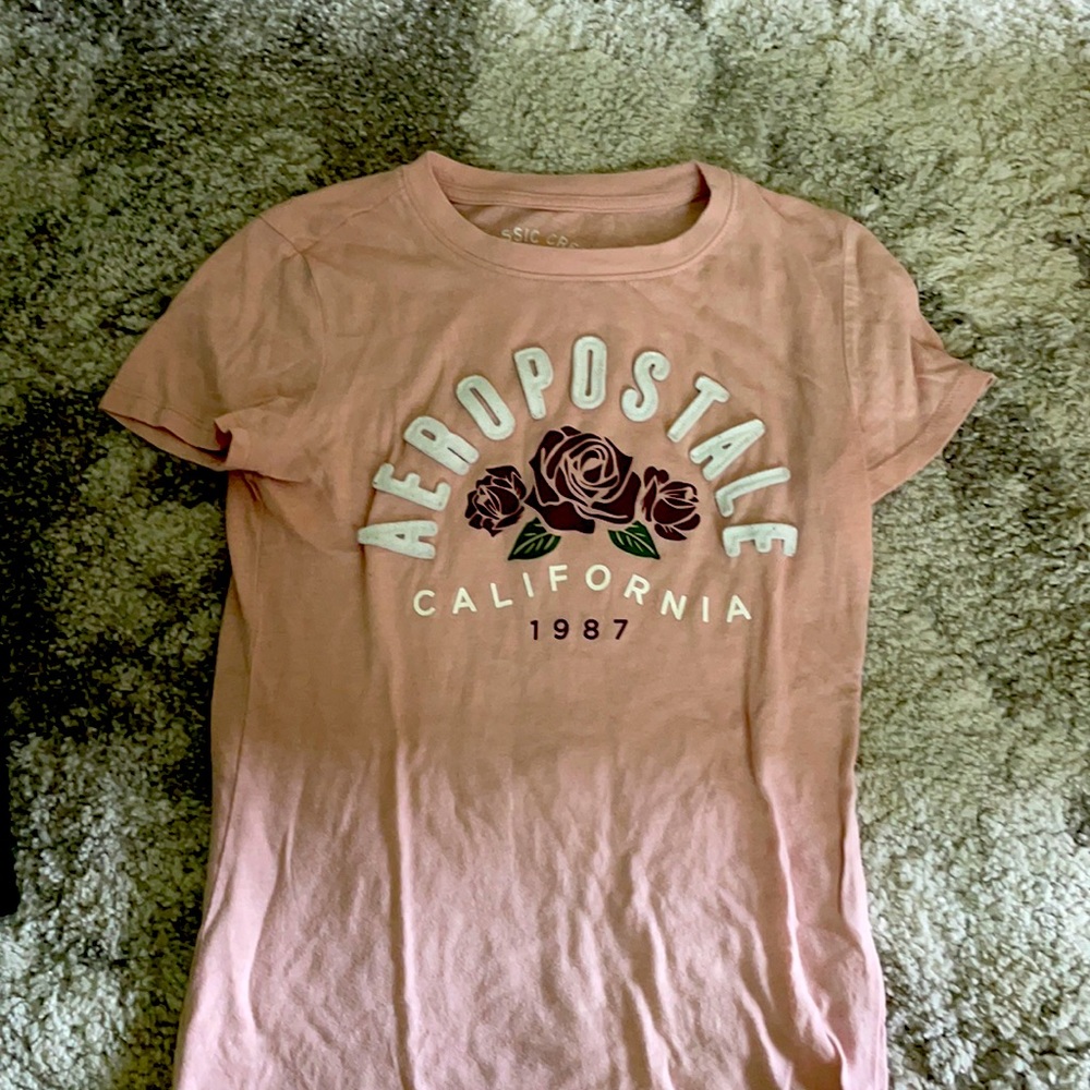 This is a light pink shirt with roses on it